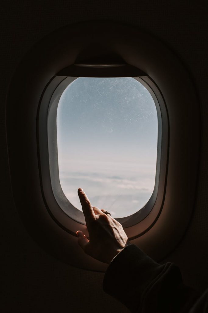 Lagu Sempurnakan Hariku – Rey Mbayang person pointing to the sky from an airplane window