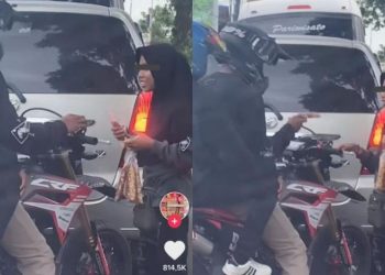 Pengendara motor membeli kacang di lampu merah.