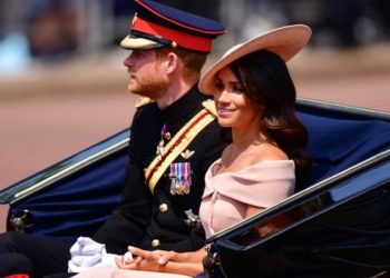 Gaya busana Meghan Merkle mengenakan gaun off shoulder.